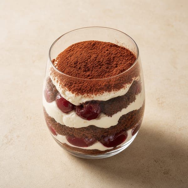 Czarne tiramisu z bitą śmietaną i wiśniami